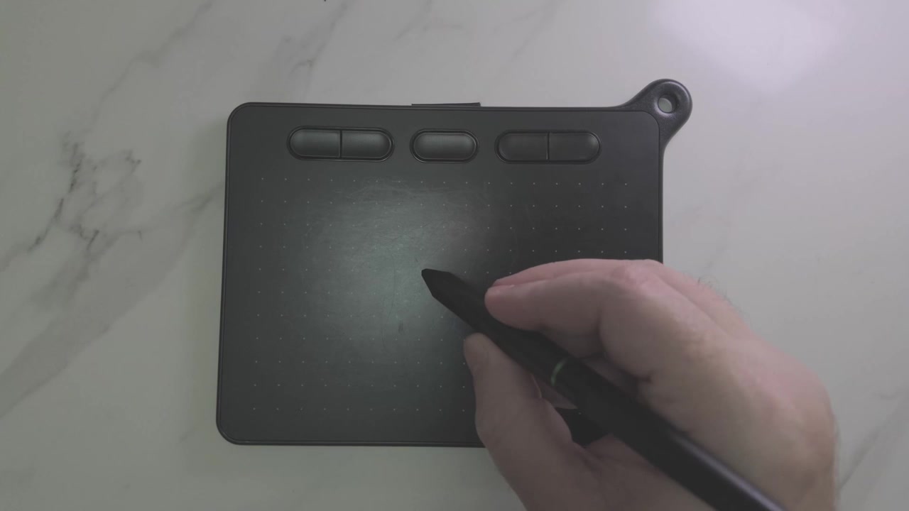 Close up of a Artist using a digital stylus on a sleek graphics tablet to sketch a large romantic heart illustration