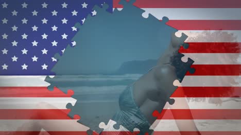 animation of american flag waving with jigsaw puzzles revealing mixed race woman on beach