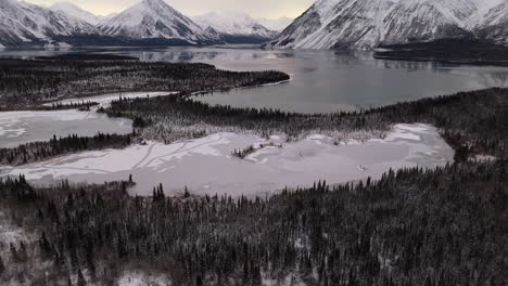 frozen kathleen lake and snow-covered forest and mountains in kluane, yukon, canada. - aerial shot