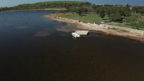 Aerial-shot-of-a-small-white-rowboat-at-a-collapsed-small-peer