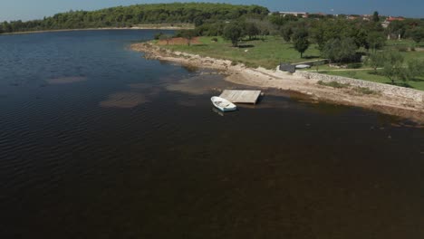 Luftaufnahme-Eines-Kleinen-Weißen-Ruderbootes-An-Einem-Eingestürzten-Kleinen-Pier