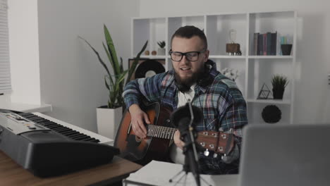 Músico-Masculino-Grabando-Y-Transmitiendo-Un-Video,-Tocando-La-Guitarra-En-Casa