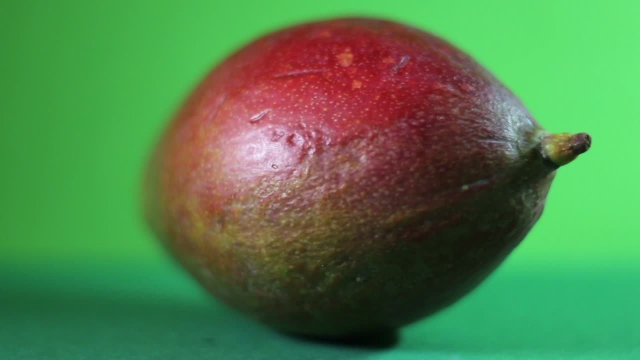 primer plano de la fruta de mango giratoria sobre un fondo verde