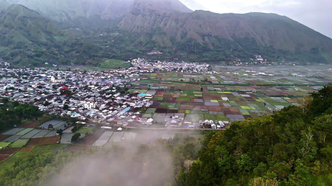 Aldeia asiática em vale nebuloso, florestas exuberantes e arrozais - Bukit Selong, Indonésia.