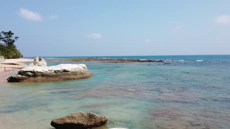 Eine-Panoramaaufnahme-Eines-Abgelegenen-Strandes-Einer-Andamaneninsel-Mit-Ein-Paar-Leuten-In-Der-Ferne,-Die-Die-Gegend-Erkunden