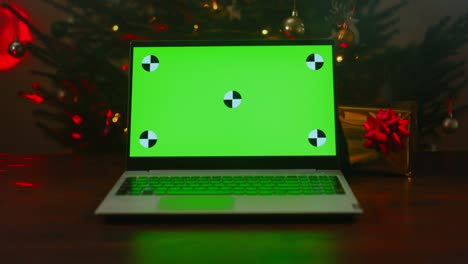 portátil con árbol de navidad y regalo. llave de croma verde para su anuncio.
