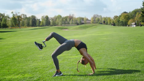 Frau-Mit-Beinprothese-Macht-Yoga-Im-Feld.-Mädchen-Steht-In-Brückenpose