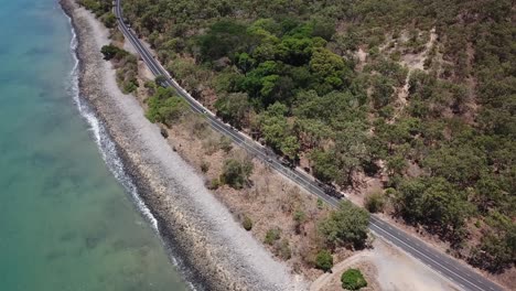 Dron-Aéreo-Panorámico-Lento-Hacia-Arriba-Para-Revelar-La-Montaña-Junto-A-Una-Playa-Tropical-Y-Una-Carretera