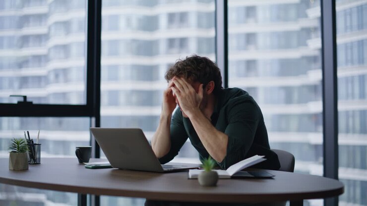 Entrepreneur reacting business failure emotionally looking laptop in workplace