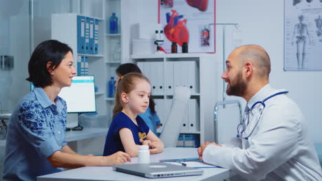 child and doctor talking in clinic