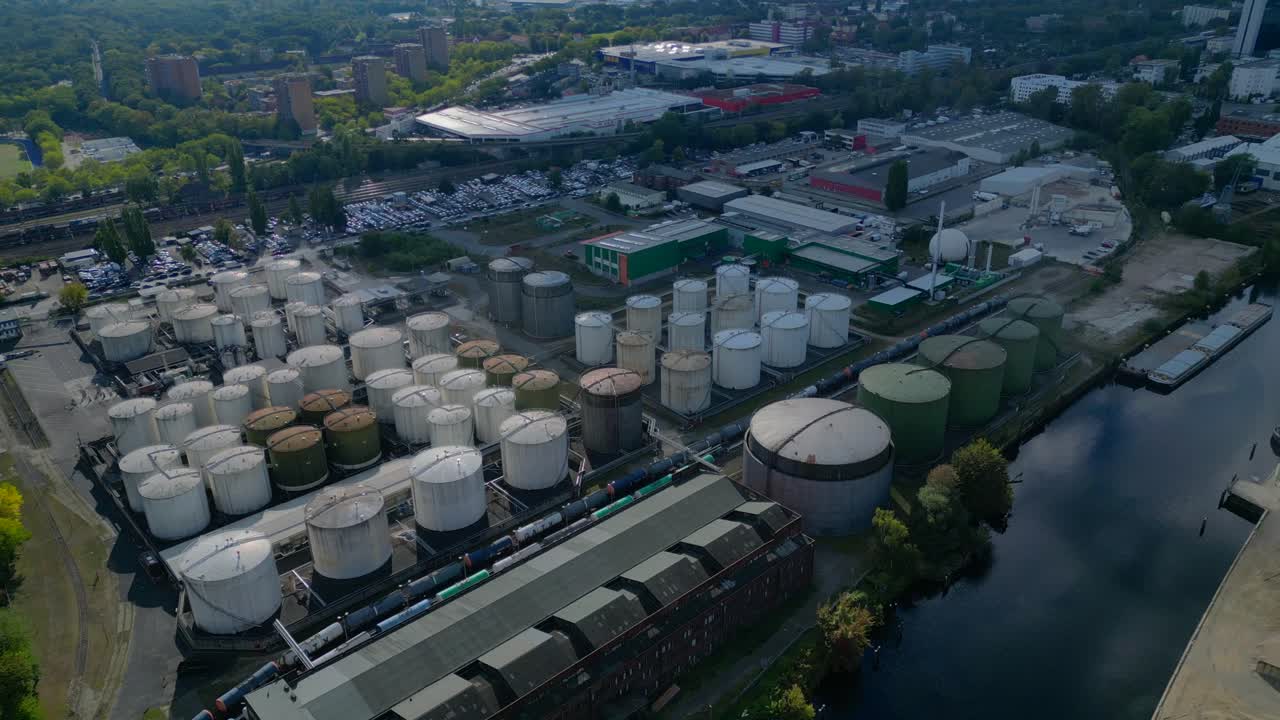 Berlin biogas plant with storage tanks by Spree river, producing renewable energy. Breathtaking aerial view flight drone camera pointing down