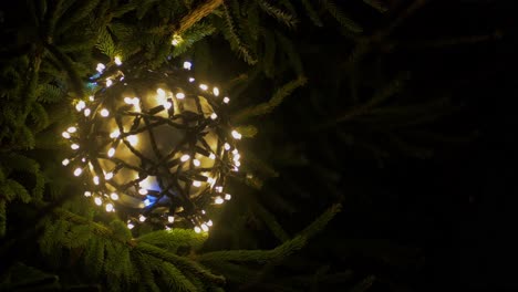 blanco cálido y azul parpadeando luces en forma de bola de navidad primer plano, adornos para árboles de navidad en la noche