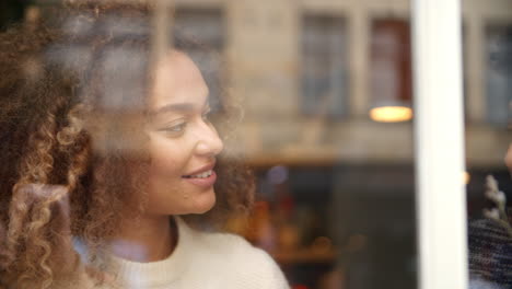 Blick-Durch-Das-Fenster-Auf-Ein-Paar,-Das-Im-Café-Sitzt