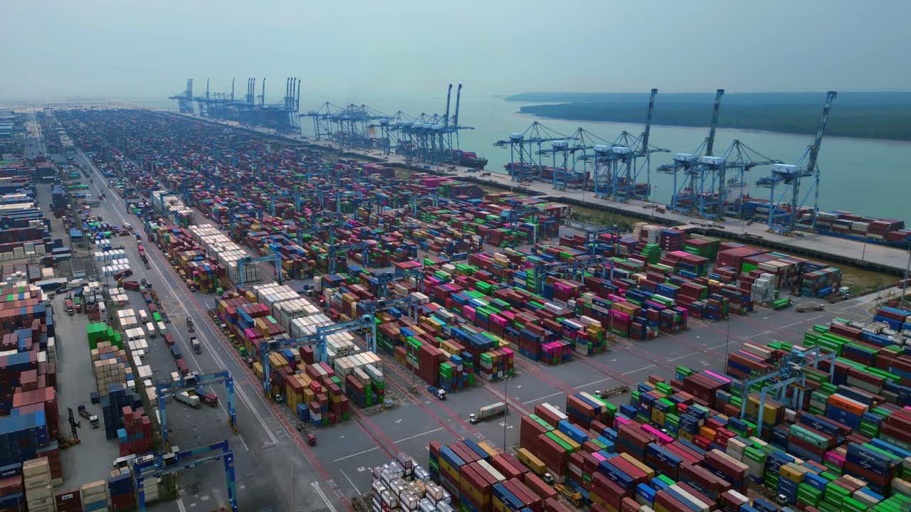 time lapse aerial view of a large container port with numerous shipping containers Trucks and cranes. Perfect aerial view fly reverse drone