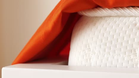 closeup of a white mattress with orange fabric cover