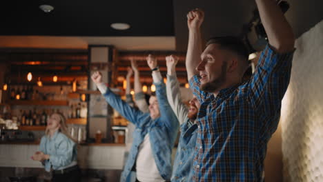 friends are watching together emotionally watching football on tv in a bar and celebrating the victory of their team after scoring a goal. watch basketball hockey. the scored puck. fans in the bar