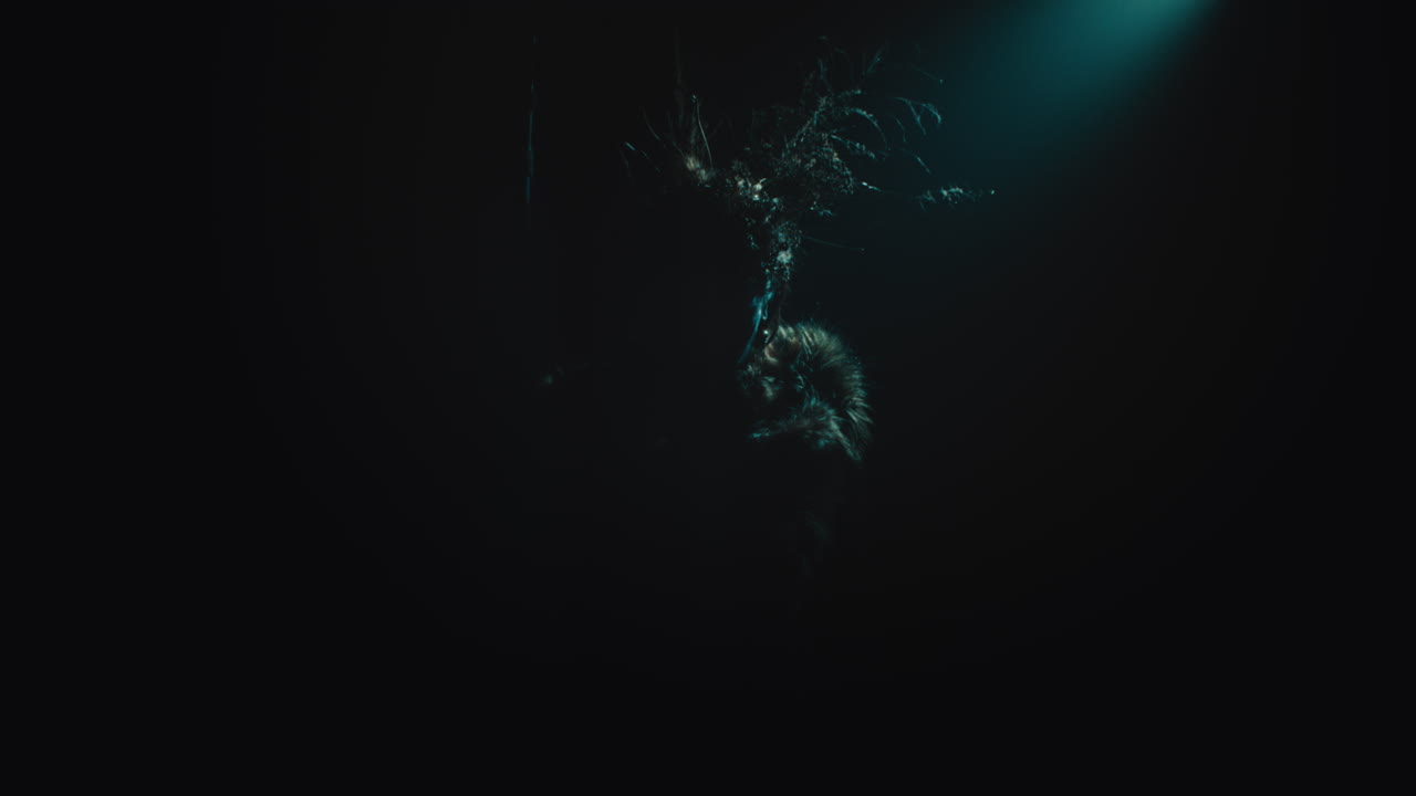 A creepy witch stands in the moody pose during the night storm