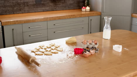 baking christmas cookies at home with rolling pin and cookie cutters, copy space