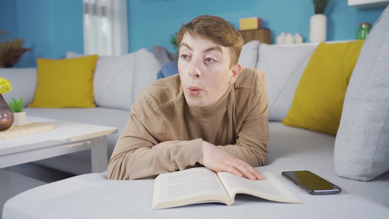 un joven admirando el libro. está sorprendido por lo que lee.