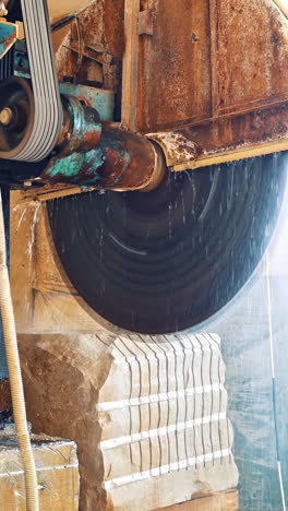 industrial marble cutting factory. marble cooled with water while cutting at factory vertical video