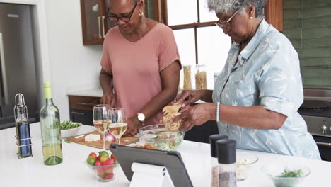 Amigas-Afroamericanas-Mayores-Enfocadas-Cocinando-Y-Usando-Tableta,-Espacio-Para-Copiar,-Cámara-Lenta