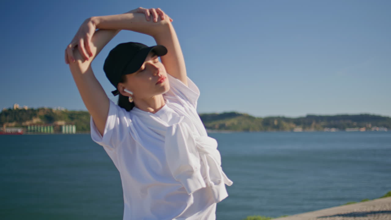 Sport girl bending body stretching muscles for morning workout on quay closeup