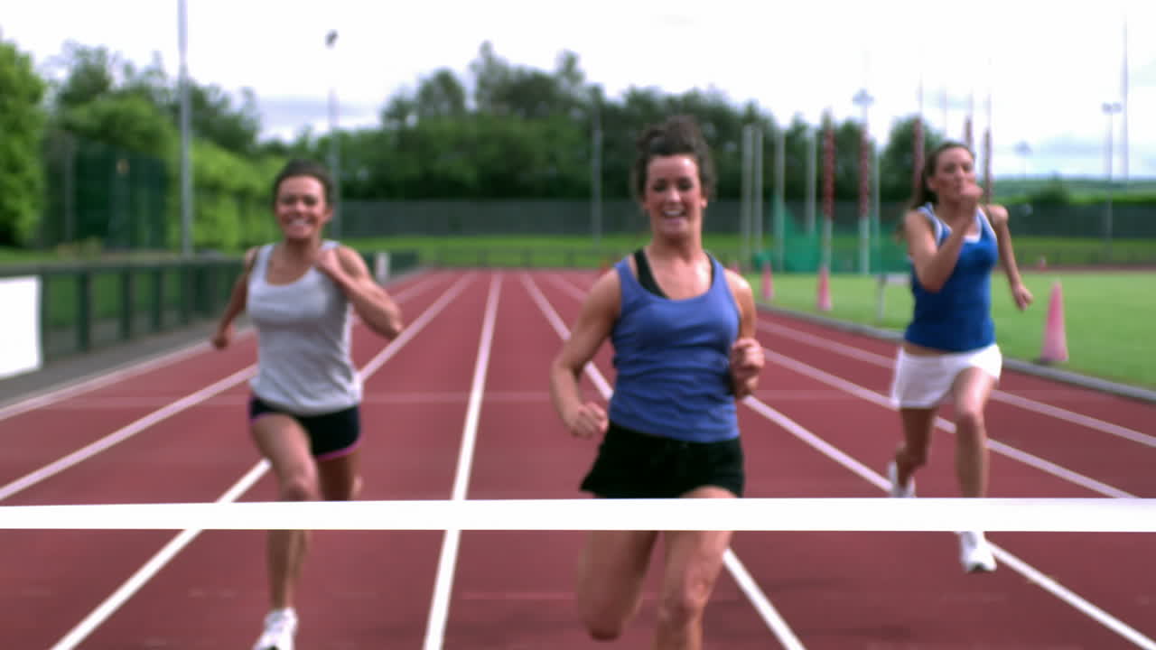 Three athletes running towards the finish line