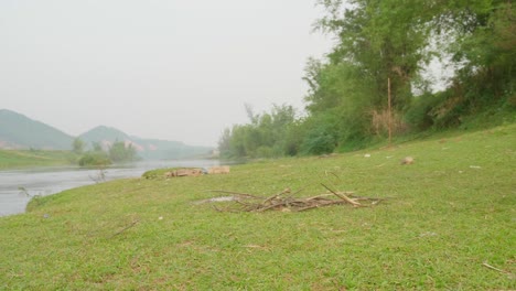 Young-man-with-bicycle-walking-near-river