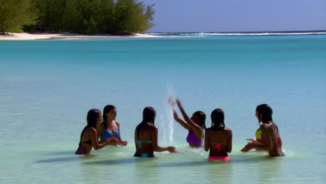 girls splashing and playing in the clear tropical ocean
