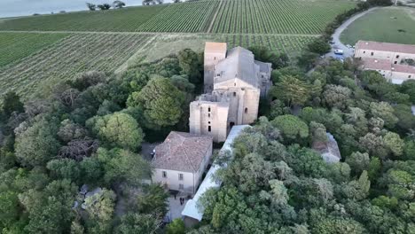 Maguelone-Roman-architecture-cathedral-from-the12th-century-near-the-Mediterranean-coast-of-France-with-seagulls,-Aerial-dolly-out-shot