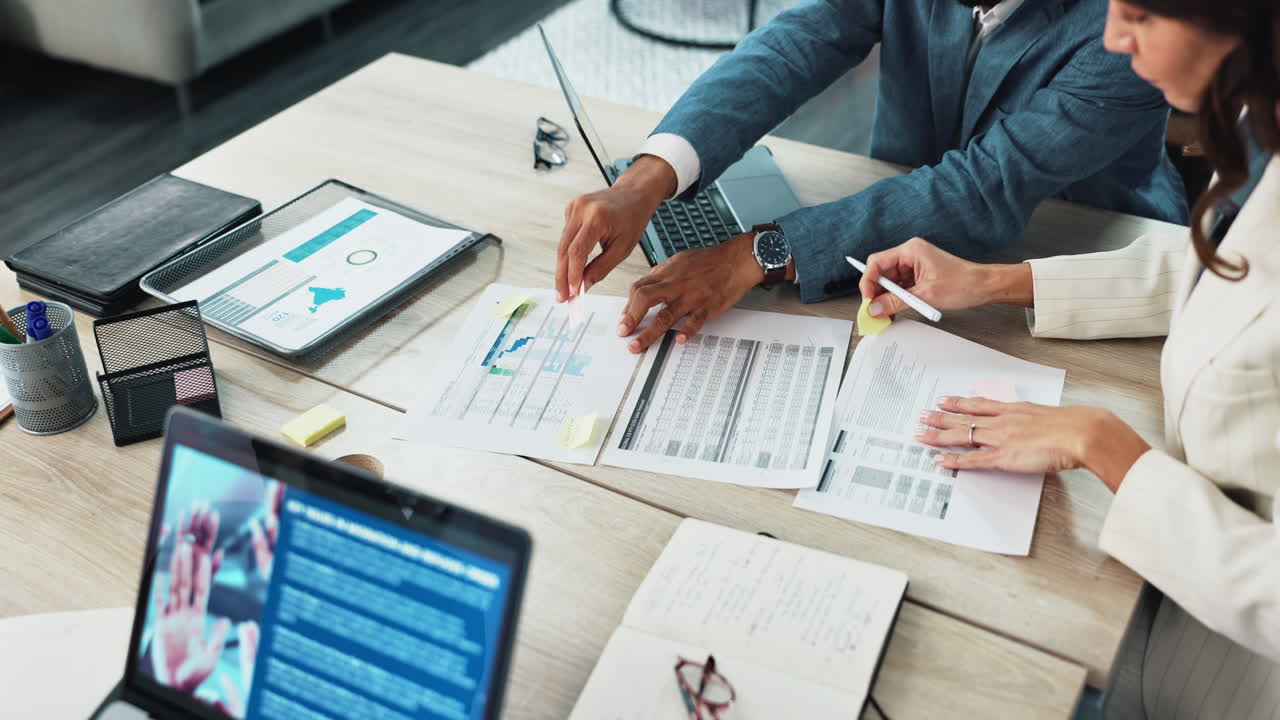 hombres de negocios reunidos en una mesa con gráficos y datos