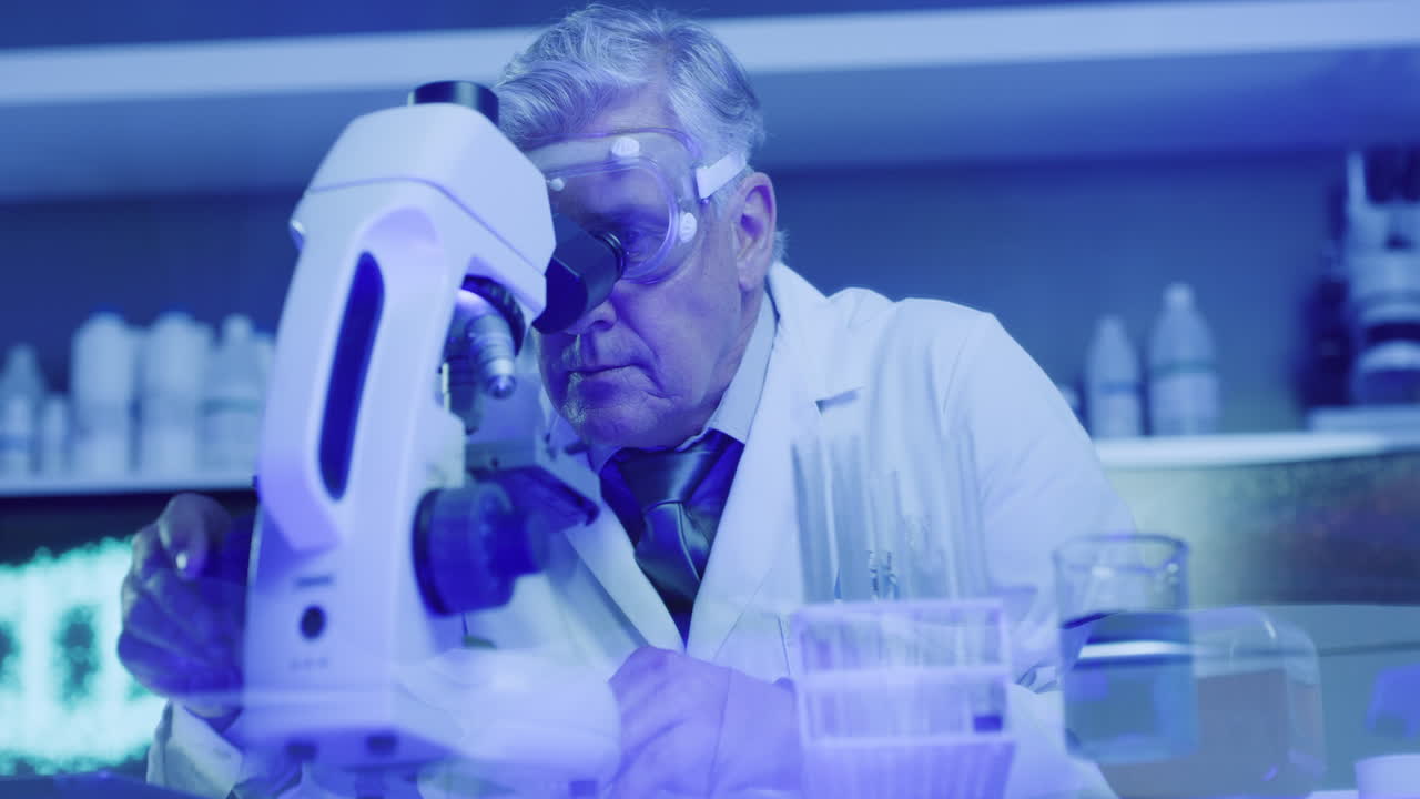 científico médico maduro usando el microscopio para