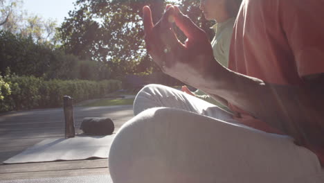 diverse couple practicing yoga meditation sitting in sunny nature, copy space, slow motion