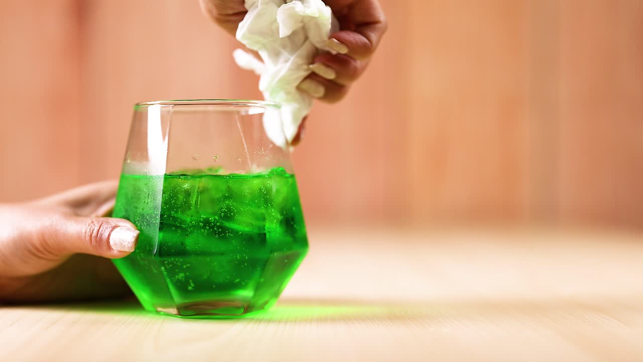 내부에 녹색 액체가 있는 손 청소 유리