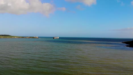 A-beautiful-blueish-and-greenish-ocean-with-a-ship-in-a-coastal-scenery