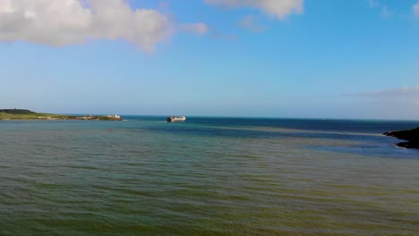 un hermoso océano azulado y verdoso con un barco en un paisaje costero