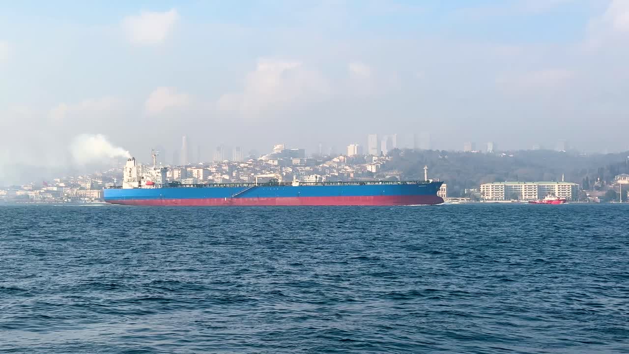 Massive cargo ship emitting smoke while sailing Bosphorus waters