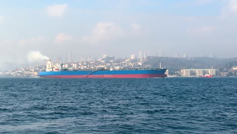 massive cargo ship emitting smoke while sailing bosphorus waters