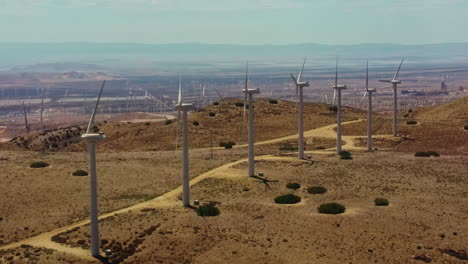 impressive view of the endless wind farm at the top of the hill connected by a service path