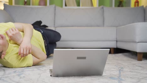 young man is confused and shocked at home on laptop.