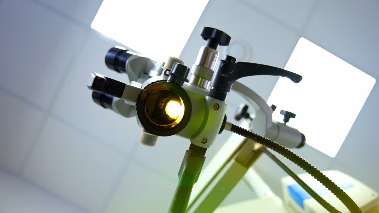 Modern enabled microscope in a lab. Scientific equipment for coronavirus testing in the laboratory. Microbiology concept. View from below on bright light from microscope.