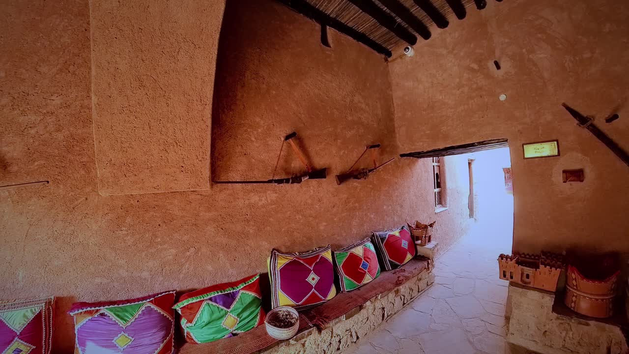 Vista intima all'interno del cortile del Museo di Taqah, cammello imbalsamato, oggetti di ceramica tradizionali e strumenti esposti, architettura ad arco che riflette la vita costiera omanita