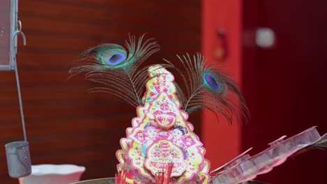 static shrine display with vibrant peacock feathers