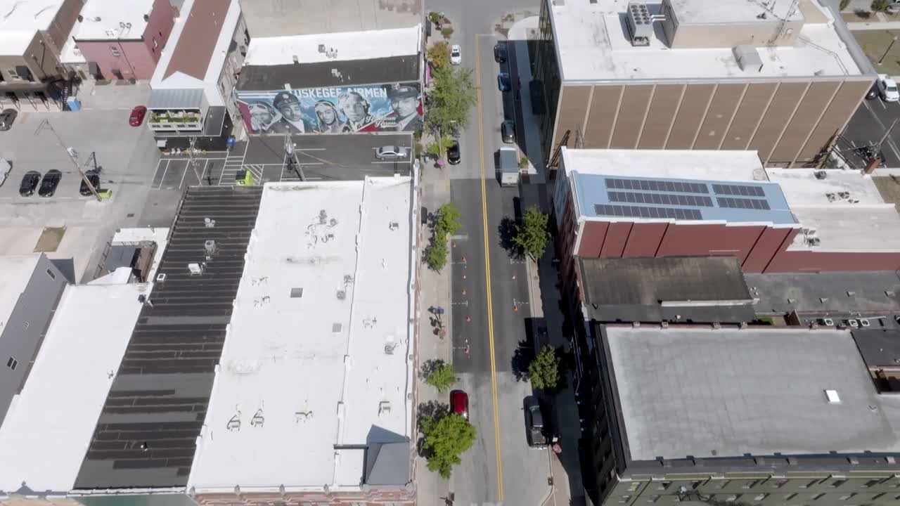 Intersección céntrica con tráfico en Kokomo, Indiana, con vídeo de dron inclinándose hacia arriba.