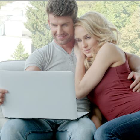 pareja joven, sentado, en, sofá, con, computador portatil