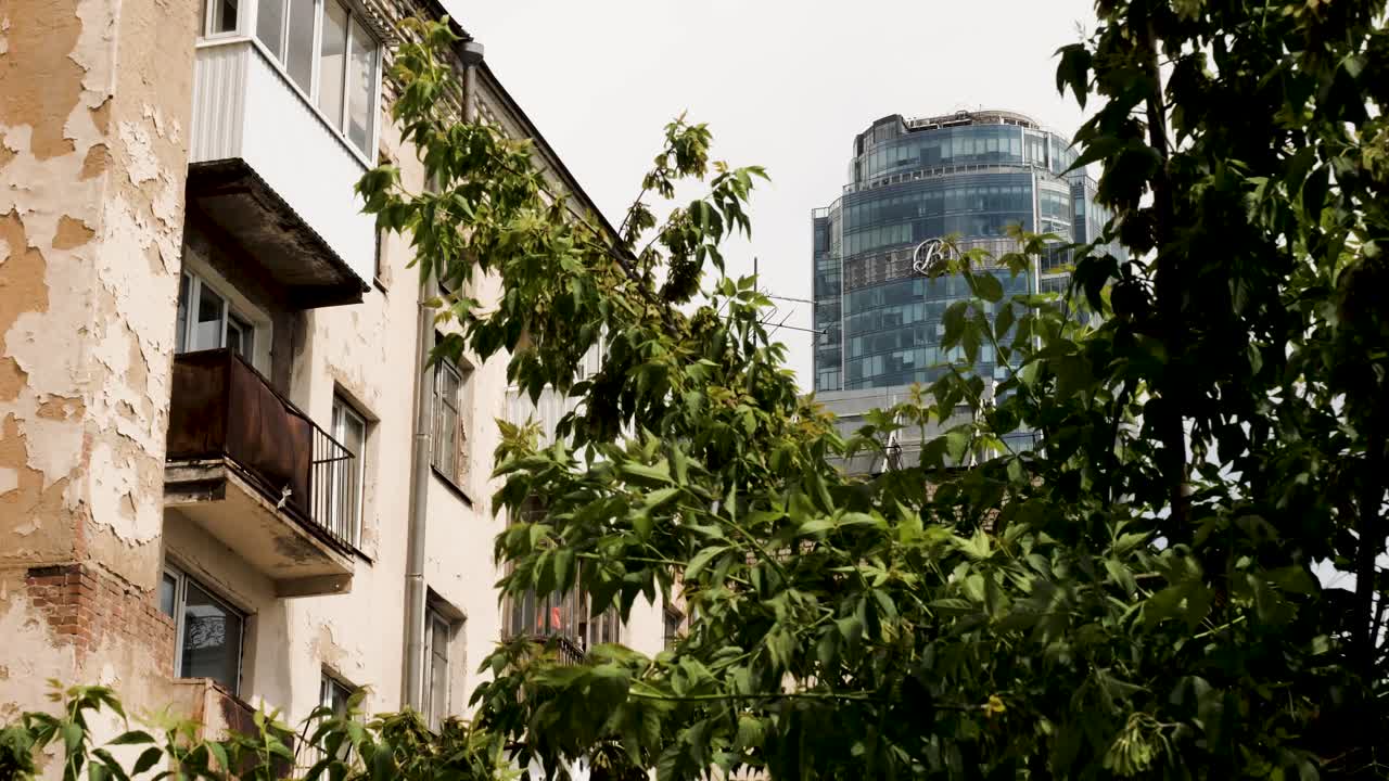 Edifício de apartamentos antigo com arranha-céu moderno ao fundo