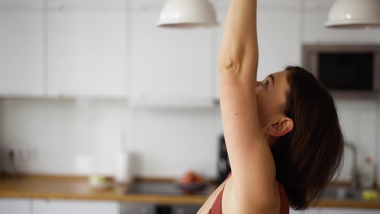 mujer en casa haciendo estiramientos, se apoya en la espalda
