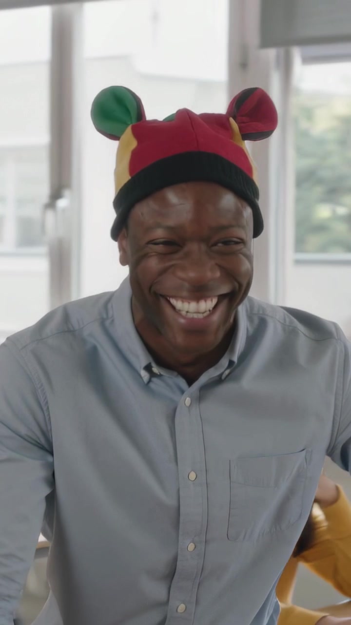 Vertical video: Laughing teacher responding to students in classroom while wearing knit hat