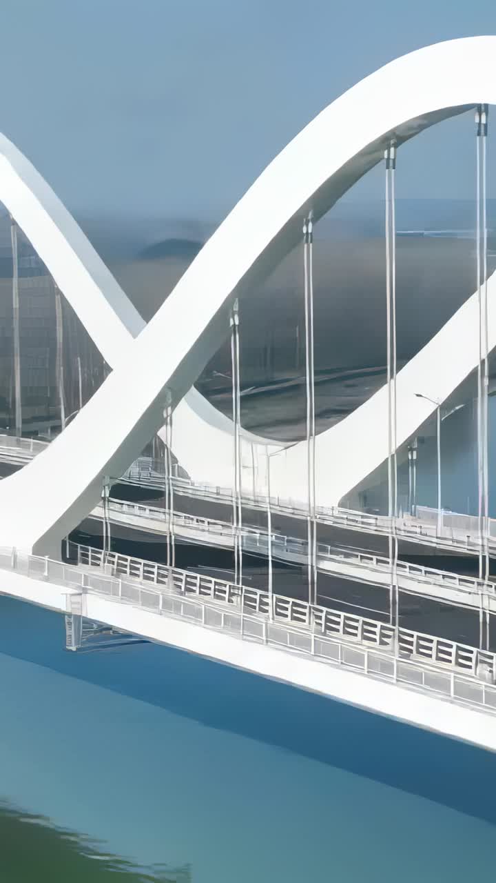 Video verticale: Drone che panoramica rivelando un ponte a doppia arcata su un fiume calmo, mostrando cavi e impalcato