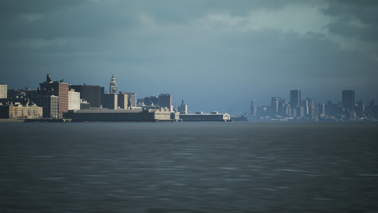 View of a city skyline against a cloudy backdrop near the waterfront at dusk